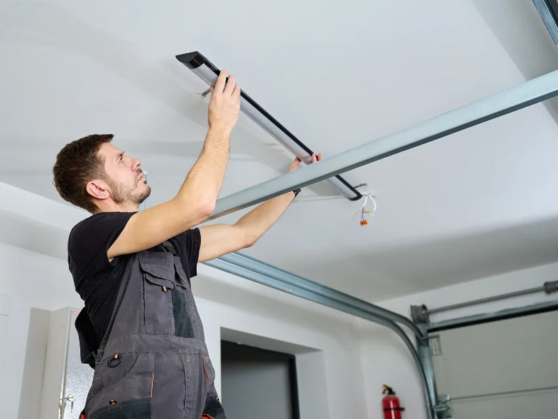 Technician adjusting garage door hardware